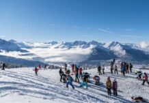 Skiurlauber und Snowboardfahrer in einem österreichischem Skigebiet.