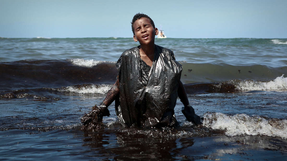 Am Itapuama-Strand bei Cabo de Santo Agostinho in Brasilien steigt im Oktober 2019 ein Junge aus dem ölverschmutzten Meer. 2000 Kilometer Küste im Nordosten Brasiliens waren zu dieser Zeit von Öl verschmutzt – die Herkunft des Öls ist bis heute unbekannt.