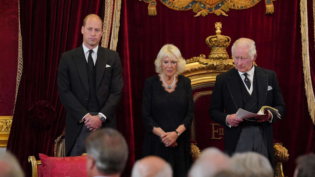 König Charles III. steht neben seinem Sohn William, Prinz von Wales (l), und seiner Gemahlin, Königin Camilla.