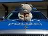 Teddybär auf Polizeiauto