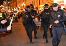 In Moskau wird ein protestierender Mann von Polizisten weggetragen.
