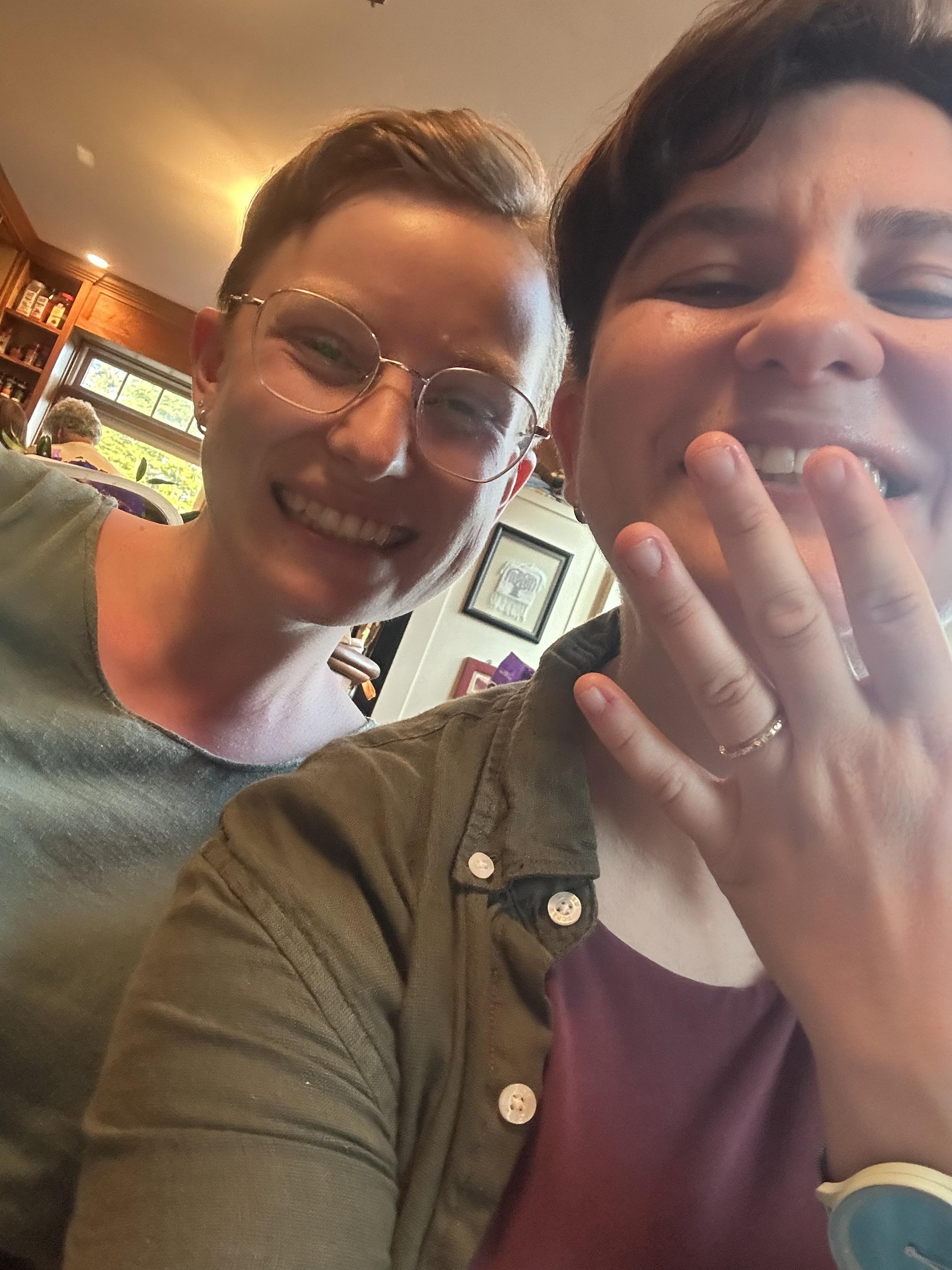 A selfie of two white lesbians, the butch brunette has an engagement ring!!!