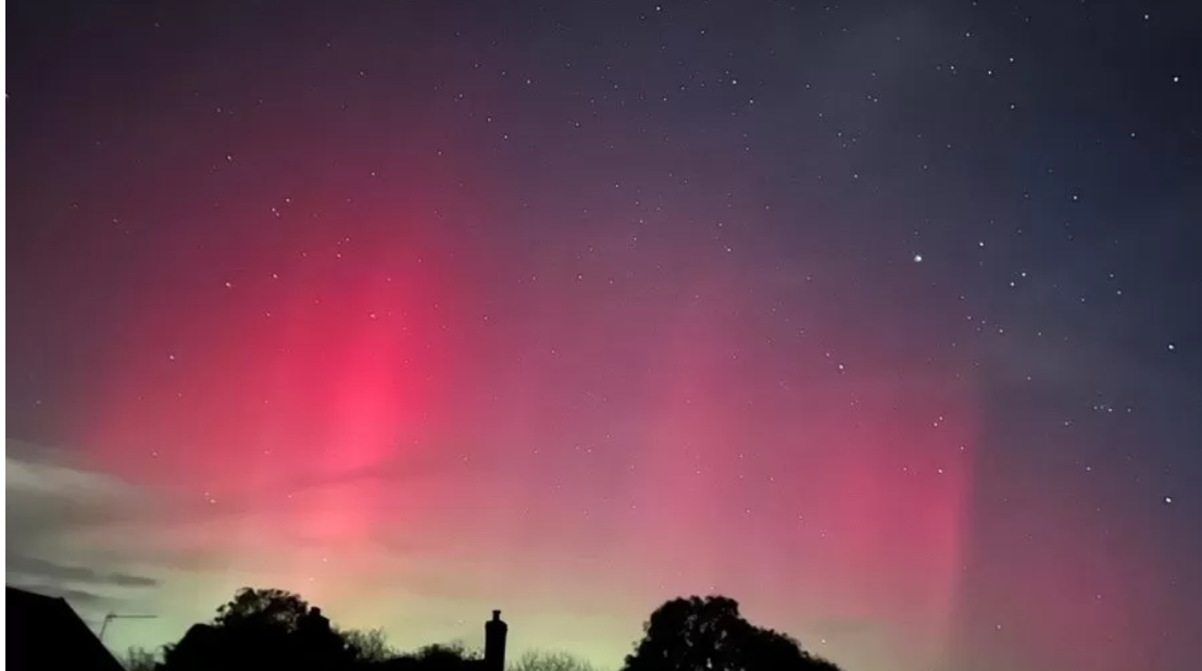 The aurora borealis paints the skies in shades of magenta over the East of England