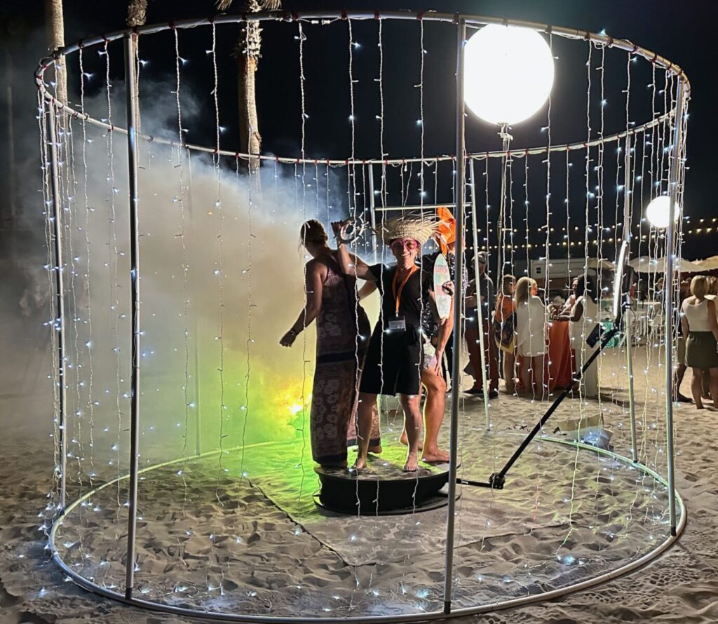 The 360 photo booth inside its lit frame on the sand at Hotel del Coronado