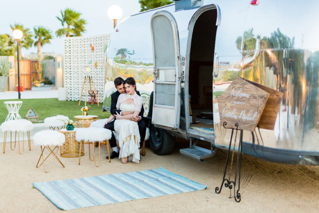 Bride and groom seated at a styled Airstream lounge during an estate wedding shoot near Palm Springs