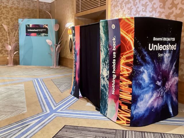 A Boomi branded walk-in photo booth enclosure at a corporate conference