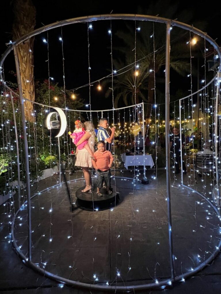 String light enclosure around a 360 photo booth at a nighttime desert party