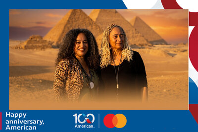 AI travel photo experience for American Airlines' 100th anniversary with Mastercard: two guests before the Pyramids of Giza and the Sphinx at sunset, Egypt.