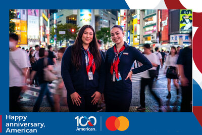 AI travel photo experience for American Airlines' 100th anniversary with Mastercard: two guests at the neon-lit Shibuya Crossing in Tokyo at night.