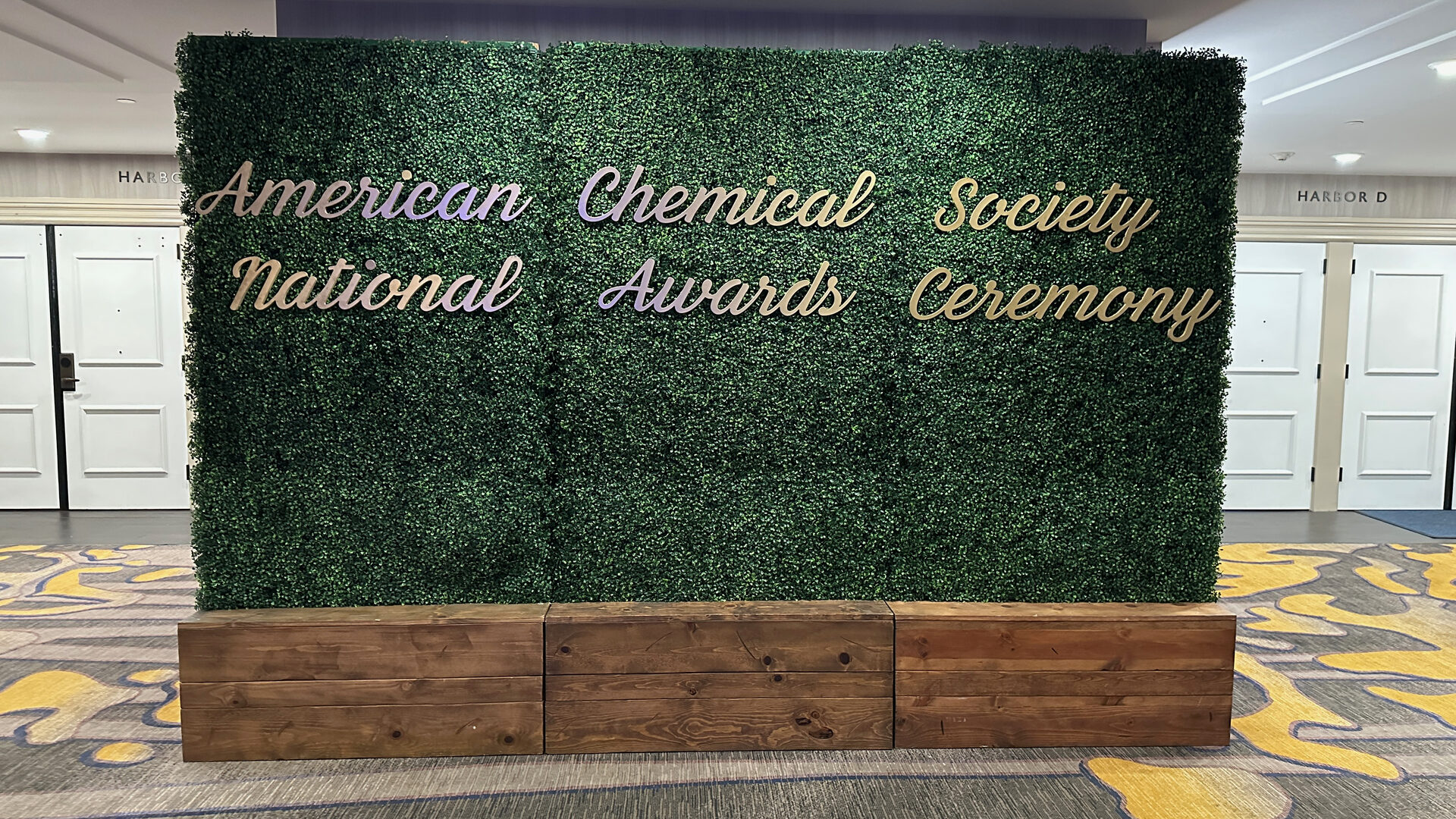 Green hedge wall reading American Chemical Society National Awards Ceremony
