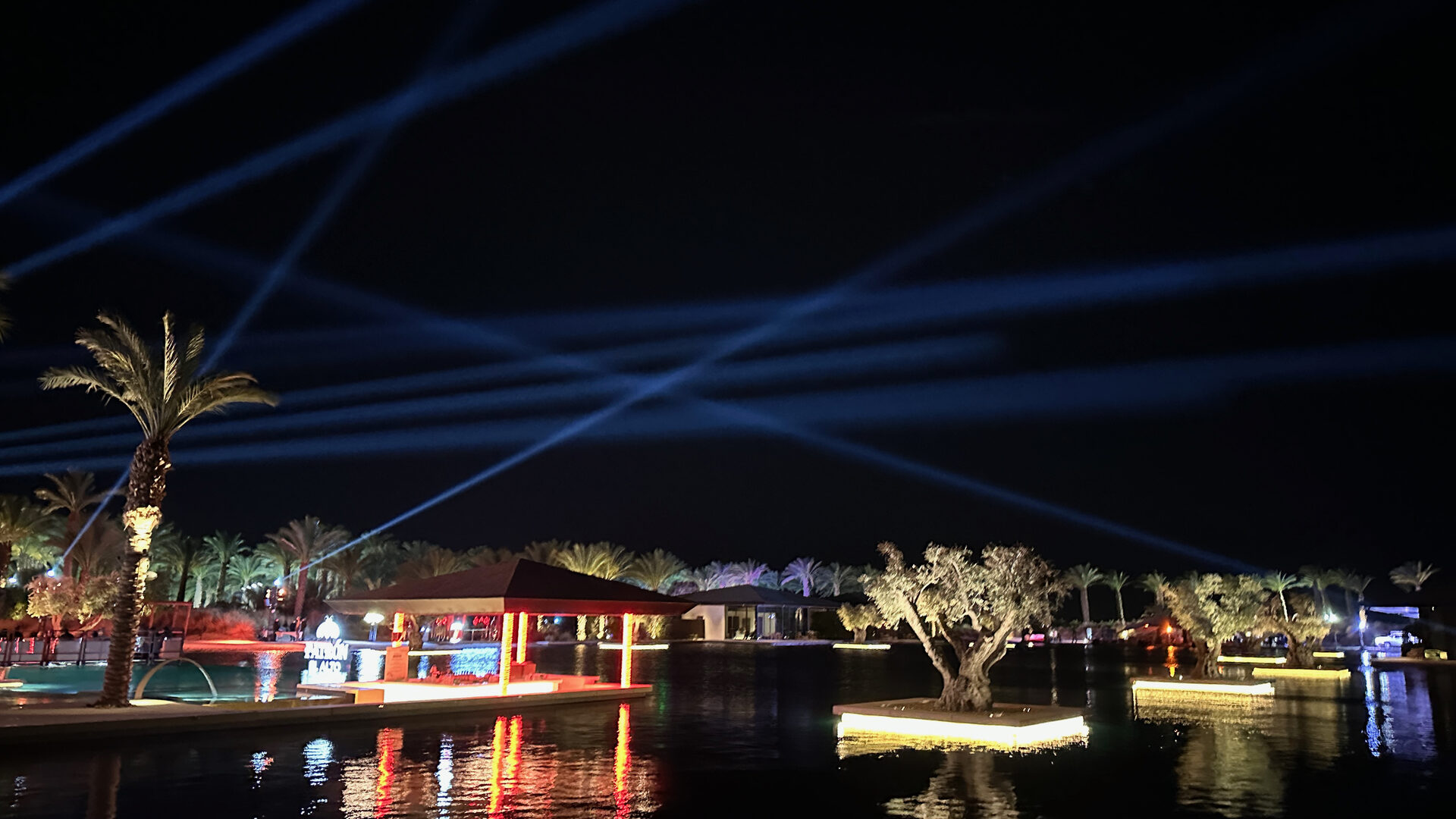 Zenyara lagoon lit at night with the venue reflected in the water
