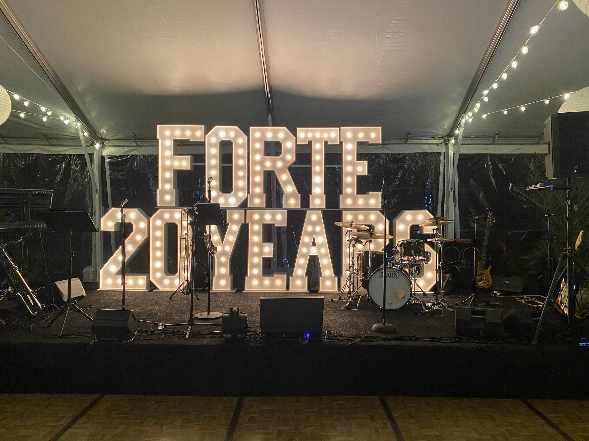 Illuminated FORTE 20 YEARS marquee letters on the stage under the tent at Waldorf Astoria Monarch Beach, Dana Point
