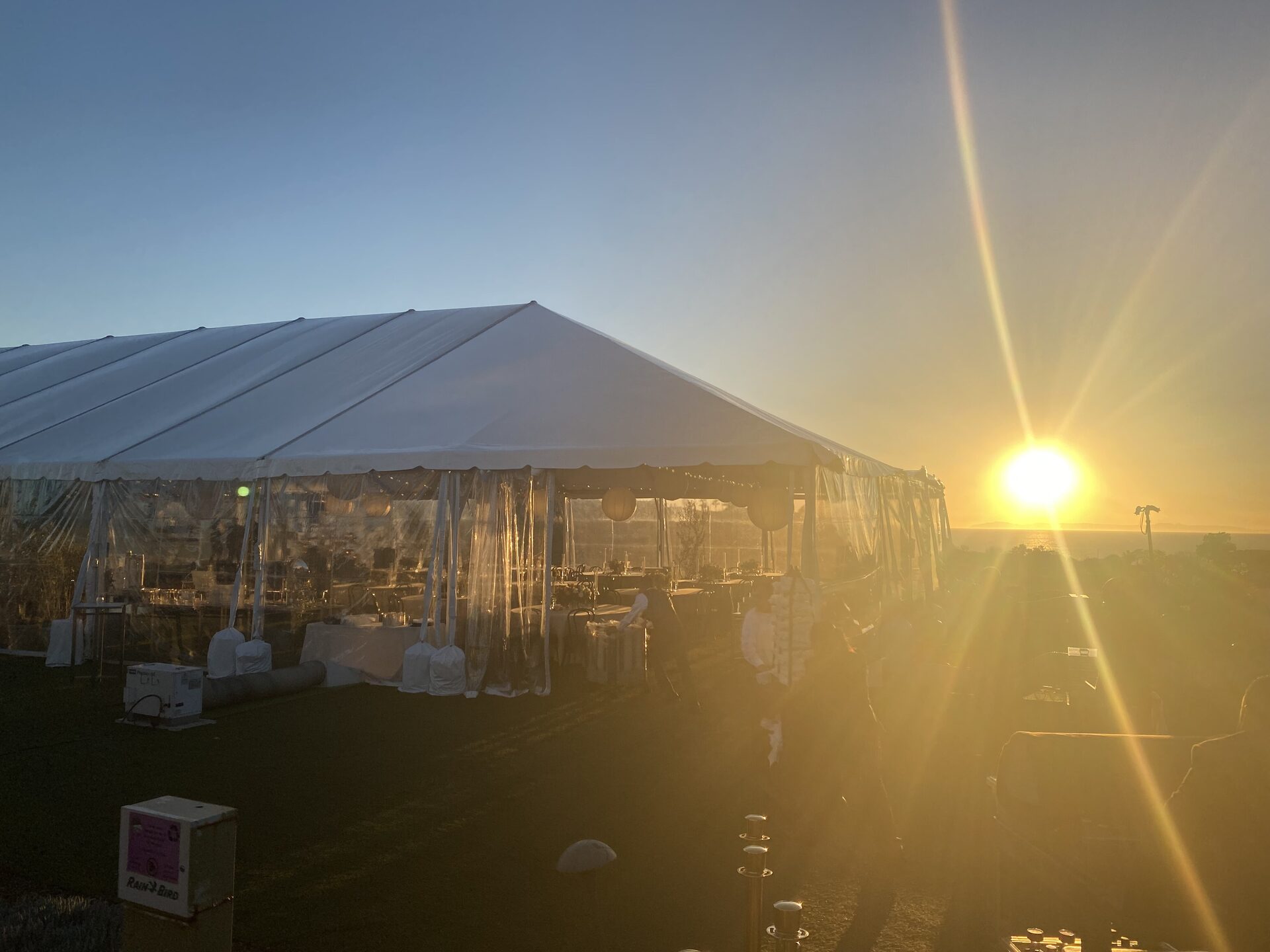 A clear-sided event tent at golden hour overlooking the Pacific at Monarch Beach Golf Links, Dana Point