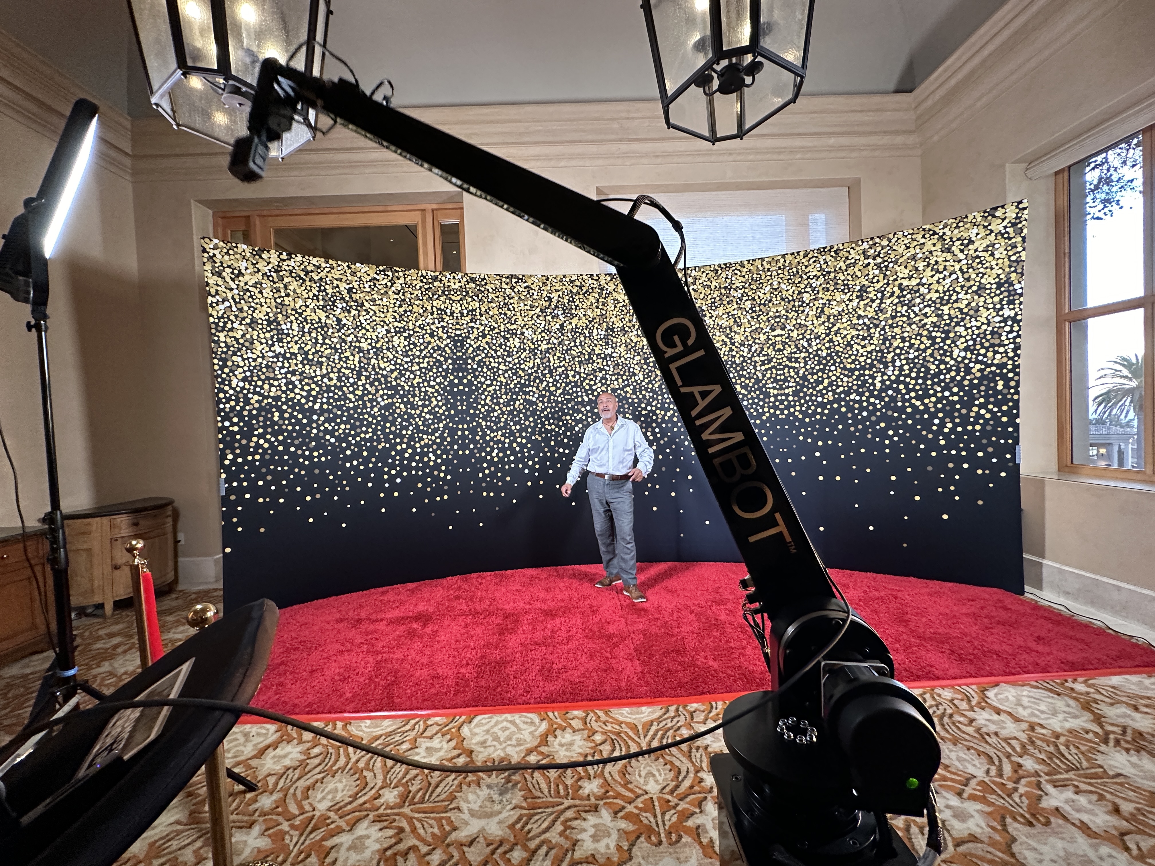 GlamBot on a red carpet with a gold glitter backdrop at Pelican Hill, Newport Beach