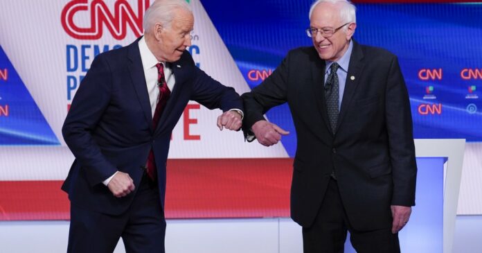 Team player Bernie Sanders leans in to help Joe Biden