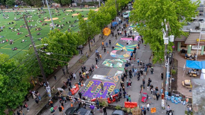 Local artists collaborate to paint a giant Black Lives Matter mural on the street