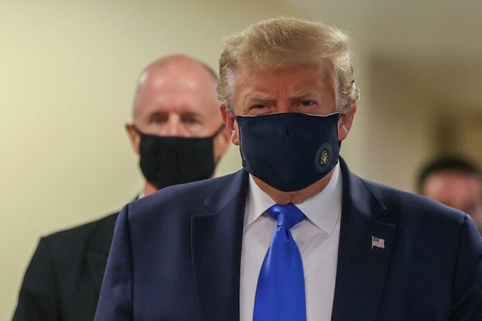 In a first, Trump dons mask in visit to a military medical facility