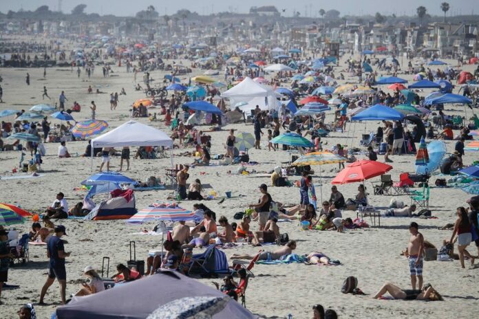 Thousands flock to beaches for holiday weekend as COVID rate soars, but death rate remains stable