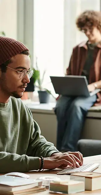 Web designer hard at work, with woman working on a website in the background.