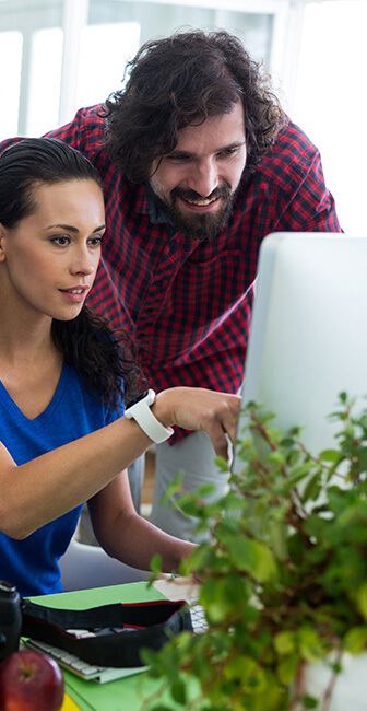 Junior web designer showing project manager results on a monitor